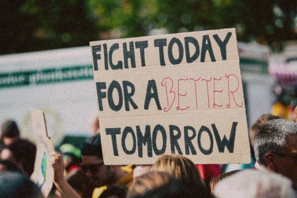 Protest sign reads 'Fight today for a better tomorrow'.