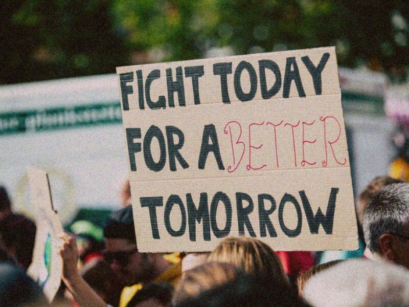 Protest sign reads 'Fight today for a better tomorrow'.
